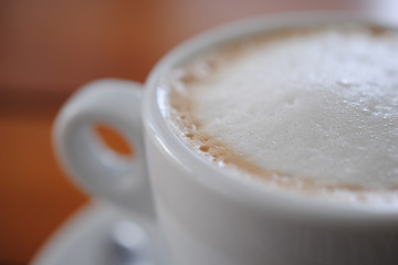 Cappuccino with foam close-up. Coffee with whipped milk. Advertising space