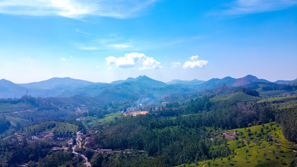 Tea plantations in Munnar, Kerala, India. Beautiful views of green hills with blue sky.
