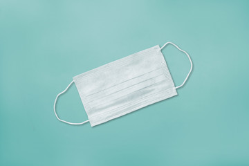 White medical mask isolated on mint background. Virus protection