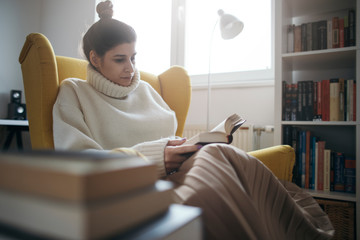 Young woman enjoy reading in armchair