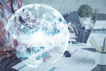 Double exposure of businessman working on laptop on background. International business hologram in front. Concept of success.