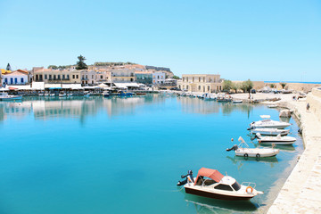 Fototapeta na wymiar Motor boats at pier in small harbor of old European city. Summer travel concept