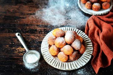 Cottage cheese donuts in a ceramic dish on a dark wooden table