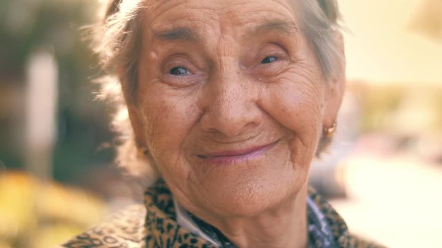 Portrait of happy smiling 92 year old senior woman outdoors. Closeup, 4K UHD, slow motion.