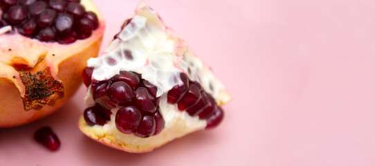 juicy sweet pomegranate on a pink background. layout for the text.
