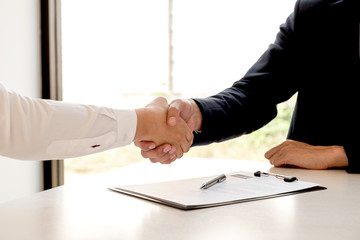 Friendly businessmen and executives join hands after successful agreement with employment contracts, recruitment and employment concepts