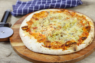 pizza aux gorgonzola et noisettes sur une planche à découper