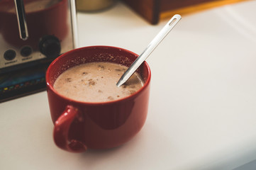 Red cup of oats sitting on white counter 