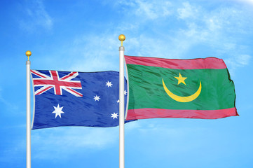 Australia and Mauritania two flags on flagpoles and blue cloudy sky