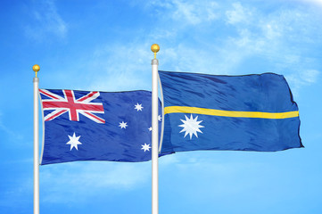 Fototapeta premium Australia and Nauru two flags on flagpoles and blue cloudy sky