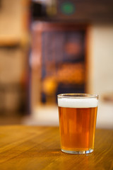 Glass of delicious draught craft beer on wooden table