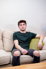 A young adult man on a sofa
