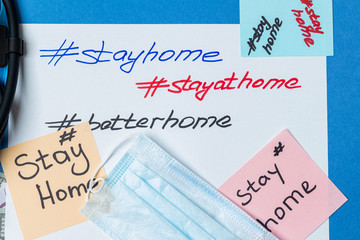 hashtag stay home lettering on paper with medical mask and copy space