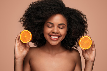 Happy black woman with ripe orange