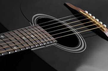Fototapeta na wymiar black acoustic guitar close up, studio light
