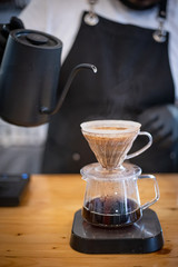 Barista pours water into the filter with coffee