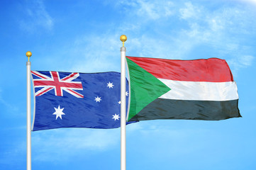 Australia and Sudan two flags on flagpoles and blue cloudy sky