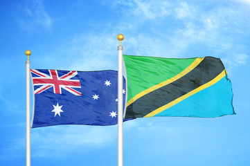 Australia and Tanzania two flags on flagpoles and blue cloudy sky