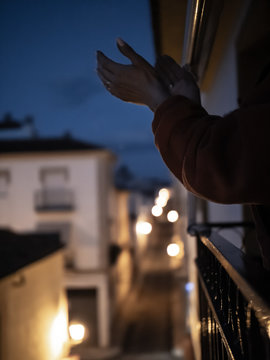 Persona aplaudiendo la labor de los sanitarios y autoridades desde una ventana a causa del coronavirus