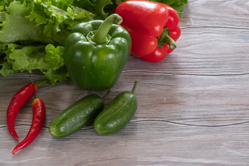 Fresh, juicy green and red vegetables on a wooden table