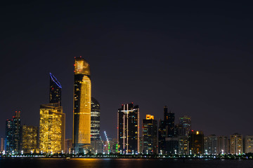Obraz na płótnie Canvas Beautiful City night view of Abu Dhabi financial and commercial district, taken during blue hour, view from marina backwater, United Arab Emirates, luxury life style, business in UAE, .