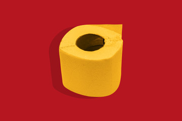Yellow toilet paper on a red background. Paper roll of paper on a colored background.