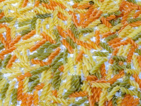 Multi-colored Pasta With The Addition Of Natural Vegetable Dye. Scattered Around The Table. Top View, Copy Space.