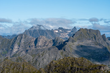Fototapeta premium Mountain peaks with rocky crags and patches of snow near Vågan, Norway
