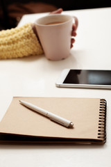 Work at home. The entry in the notebook. Cup of coffee in hand