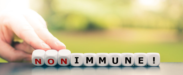 Hand turns dice and changes the expression "non immune" to "immune!".
