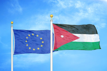 European Union and Jordan two flags on flagpoles and blue cloudy sky
