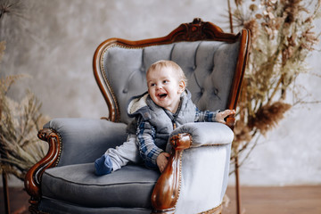 a one year old child is sitting in a chair in the bedroom