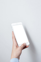 Closeup shot of a woman hold on mobile phone. Girl's hand holding a modern smartphone. Blank screen to put it on your own webpage or message.