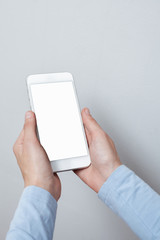 Closeup shot of a woman hold on mobile phone. Girl's hand holding a modern smartphone. Blank screen to put it on your own webpage or message.