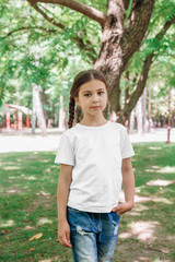 Fototapeta premium Girl kid wearing white blank t-shirt with space for your logo or design outdoor