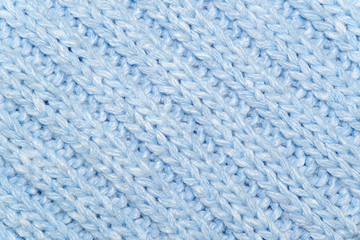 Blue knitted wool fabric background. Very warm natural knitwear. Handmade activity.