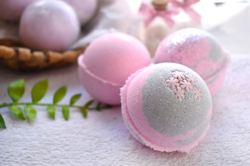 Close up romantic spa composition. Pink bath bombs on lights background. Love or health lifestyle concept. Copyspace.
