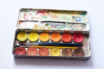 Watercolor paint set which has been used for years with its old brushes suitable for painters and Watercolor painting subjects, Selective focus on pan colors