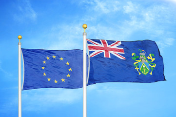 European Union and Pitcairn Islands two flags on flagpoles and blue cloudy sky