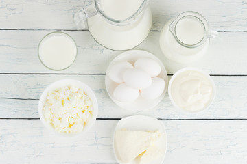 Different dairy products on the white wooden boards
