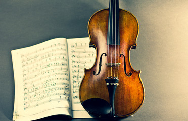 Fototapeta na wymiar Violin on a gray background. Violin and sheet music.