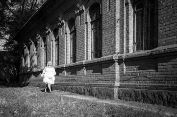 blonde girl in a white dress on nature near architectural monuments in the open air