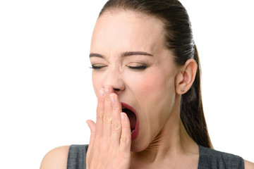 The girl yawns on a white background