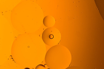 Abstract background from mixed water and oil bubbles in orange color