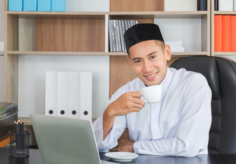 Happiness young business arab middle eastern man drinking coffee in office happy and smile face