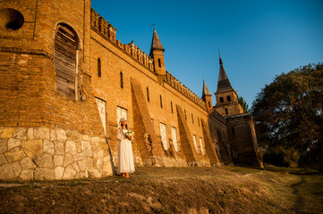 blonde girl in a white dress on nature near architectural monuments in the open air