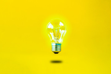 levitating burning bulb on a yellow background