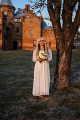 Obraz premium blonde girl in a white dress on nature near architectural monuments in the open air