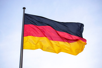 Germany flag waving in the wind close-up against a blue sky