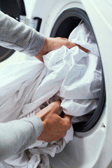 man putting clothes into the washing machine
